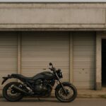 シャッターが閉まったバイク販売店と停められたオートバイの風景